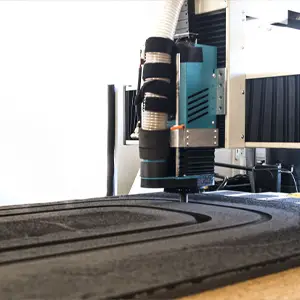 Machine CNC découpant un plateau en mousse sur mesure dans nos ateliers